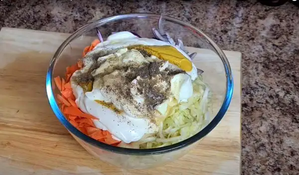 Shredded cabbage, carrots, and red onion in a bowl before mixing the dressing.