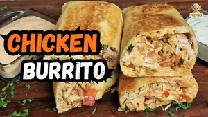 Homemade chicken burrito cut in half, filled with juicy chicken, rice, fresh vegetables and melted cheese, served with creamy and smoky sauces.