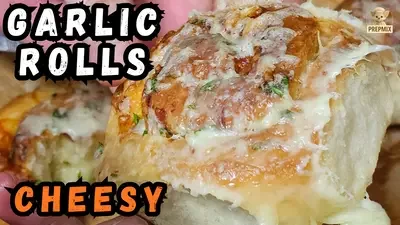 Homemade cheesy garlic bread rolls baked until golden, topped with melted grated cheese, garlic butter and fresh parsley.